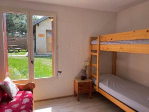 a bedroom with a bunk bed and a window at Les Chalets de Montclar Azur et Neige in Montclar