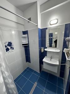 a blue and white bathroom with a sink and a mirror at Romula Imperial in Caracal