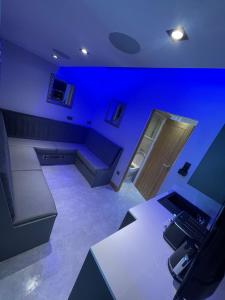 um quarto com um quarto azul com um sofá e uma secretária em Belvedere Aparthotel - 83 Mount Pleasant em Liverpool
