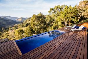 a swimming pool on a deck with a view of the mountains at Pousada Villa Catarina in Gonçalves