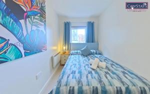 a bedroom with a bed and a painting on the wall at Triumph House - 3 bed 2 bath Apartment in Coventry City Centre, sleeps 6, Free secured parking, balcony, by COVSTAYS in Coventry