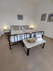 a room with three beds and a table and chairs at Paros Reppas House "Livadia" in Parikia