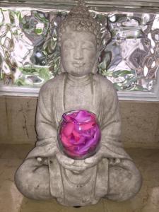 una estatua de un buddha sosteniendo un cuenco púrpura en Hotel Le Festival, en Cannes