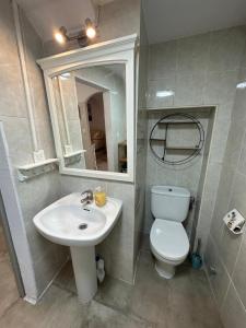 bagno con lavandino, servizi igienici e specchio di Charming apartment in historic center Tarifa a Tarifa