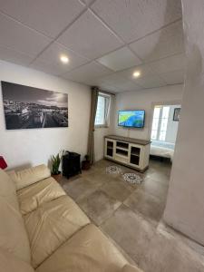 ein Wohnzimmer mit einem Sofa und einem Flachbild-TV in der Unterkunft Charming apartment in historic center Tarifa in Tarifa