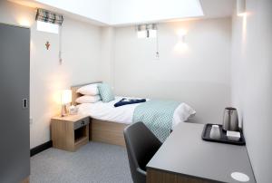 Mały pokój z łóżkiem i biurkiem w obiekcie Theodore House w mieście Clitheroe