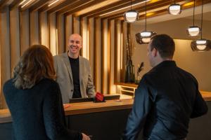 a man standing at a counter with two people at Genusshotel "Zum Wendl" in Freyung