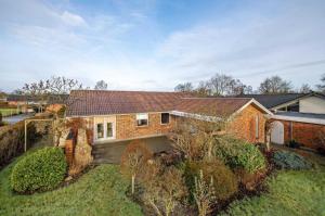 a brick house with a roof on a yard at Central Microflat, free parking, garden BBQ, LegoHouse, Legoland, in Billund