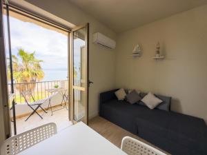Habitación con cama y balcón con patio. en Caronì - Casa Sul Mare, en Caronia Marina