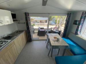 a kitchen with a table and a dining room with a view at Camping Le Repos in Saint-Palais-sur-Mer