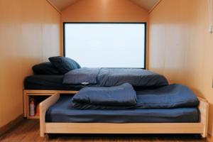 um quarto com três almofadas azuis num quarto em Bobocabin Madasari, Pangandaran em Bulakbenda
