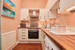 a kitchen with white cabinets and a counter top at Lovely Chique Newcastle Abode - Sleeps 4 in Elswick