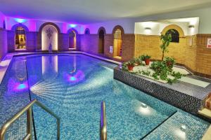 a swimming pool in a building with purple lighting at The Sefton in Douglas