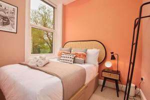 a bedroom with a bed with orange walls and a window at Lovely Chique Newcastle Abode - Sleeps 4 in Elswick