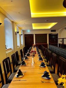 a long long table in a room with chairs and tables at Pension "Zum Reußischen Hof" in Thallwitz