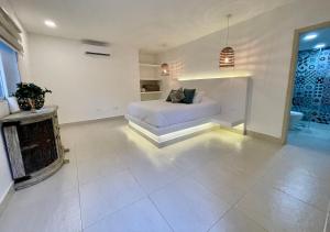 a white bedroom with a bed and a fireplace at Hotel La Finca Buritaca by DOT Premium in Buritaca