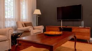 Andrella Home Arusha في أروشا: غرفة معيشة مع طاولة قهوة وتلفزيون بشاشة مسطحة