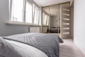 um quarto com uma cama grande e uma janela em Vorto Apartament 2 - Warszawa Centrum em Varsóvia