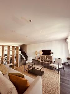 een woonkamer met een bank en stoelen en een tv bij Duplex lumineux rénové avec terrasse et bains de soleil in Cannes