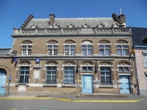 an old brick building with blue doors and windows at Loft 'Le Télégraphe' in Cassel