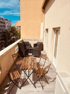 een patio met stoelen en een tafel op een balkon bij Duplex lumineux rénové avec terrasse et bains de soleil in Cannes