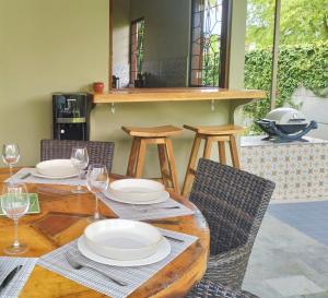 塞隆貝拉納克的住宿－Villa Jeruk，一张木桌,上面有玻璃杯和盘子