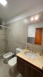a bathroom with a sink and a toilet and a mirror at Círculos del Lago in Villa Carlos Paz