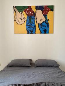 una pintura colgada en una pared junto a una cama en Love at First Sight Apartment en Batumi