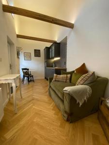 a living room with a green couch and a table at Pension Gablenz in Chemnitz