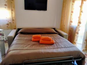 un letto in una camera con due cuscini arancioni sopra di Le Camelie appartamento a Bosa