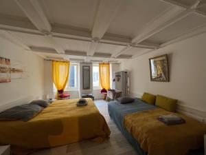 a bedroom with two beds and a couch at Au clair de la Lune - jusqu'à 4 personnes, centre historique in Porrentruy