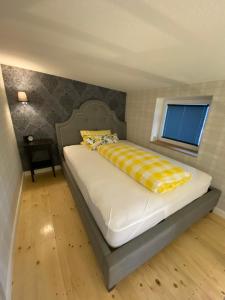 ein Schlafzimmer mit einem Bett mit einer gelben und weißen Decke in der Unterkunft Pension Gablenz in Chemnitz