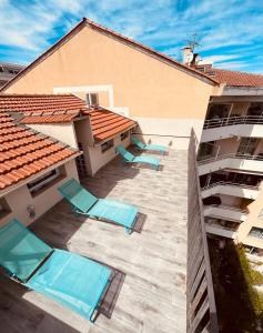 een patio met ligstoelen en een gebouw bij Duplex lumineux rénové avec terrasse et bains de soleil in Cannes