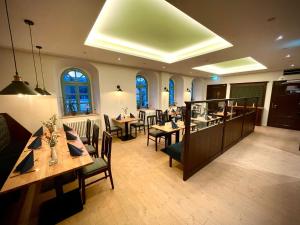 restauracja ze stołami i krzesłami w pokoju w obiekcie Pension "Zum Reußischen Hof" w mieście Thallwitz