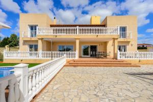 duży dom z białym płotem i patio w obiekcie Villa next to playa Bossa w mieście San Jose de sa Talaia