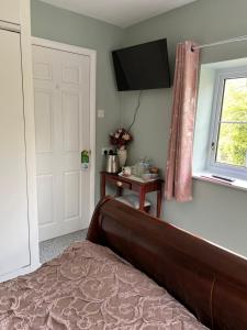 a bedroom with a bed and a television on the wall at Canalside B and B 