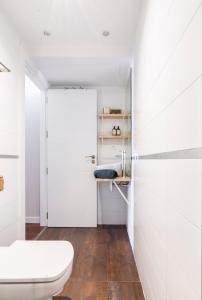 Un baño blanco con inodoro y lavabo. en Livemalaga Boutique Apartments, en Málaga