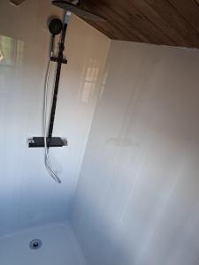 a shower in a white wall with a microphone at Cabane Spa Nord'GOUIS in Cournon-dʼAuvergne