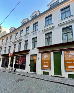 un grande edificio bianco con porte verdi su una strada di Home Sweet Home a Riga