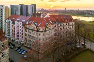 德勒斯登的住宿－N vogue Apartment - Außergewöhnliche Unterkunft in Zentrumsnähe，一座城市中红色屋顶的大型建筑