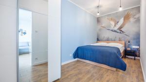 a bedroom with a bed and a painting of birds at Apartamenty Sun & Snow Sagaris z basenem in Dziwnów