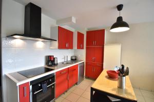 une cuisine avec des placards rouges et un comptoir en bois dans l'établissement Cap Marina - Capbreton proche port de plaisance appartement 4 personnes, à Capbreton