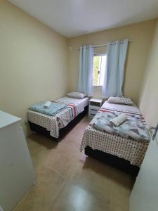 a bedroom with two beds and a window at Ipê Eco Village in Penha