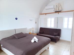 a bedroom with a bed and a couch at Top Oia in Oia +64 photos