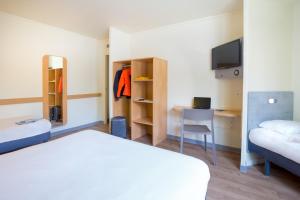 Habitación de hotel con 2 camas, escritorio y TV. en ibis budget Aubagne Paluds Agora, en Aubagne