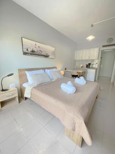 a bedroom with a large bed with two towels on it at Rhodes Central: King Bed Studio in Rhodes Town