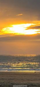 a sunset over a beach with the ocean at Appartement 100 m de la plage in Saint-Palais-sur-Mer +1 photo