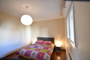 - une chambre avec un lit doté d'une couette colorée et d'une fenêtre dans l'établissement Cap Marina - Capbreton proche port de plaisance appartement 4 personnes, à Capbreton
