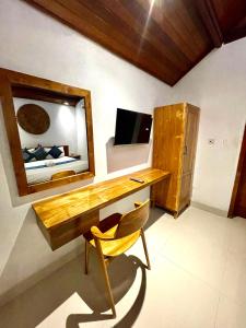 a desk in a room with a mirror and a bed at DIMUWA Ubud in Ubud