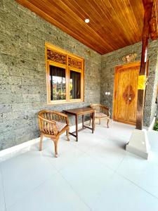 a patio with two benches and a table and a window at DIMUWA Ubud in Ubud